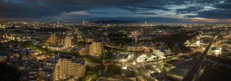Photo for Panoramic night view city lights and intersection by train tracks with sunset afterglow in sky. High quality photo - Royalty Free Image