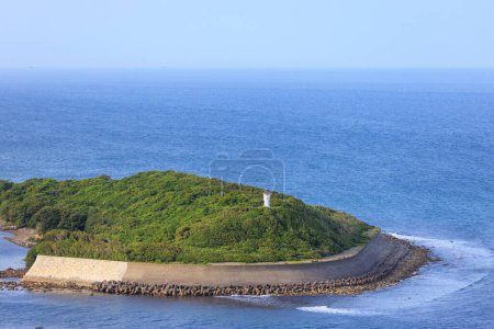 Téléchargez les photos : Béton mur de mer protège le littoral sur une petite île verte avec phare. Photo de haute qualité - en image libre de droit