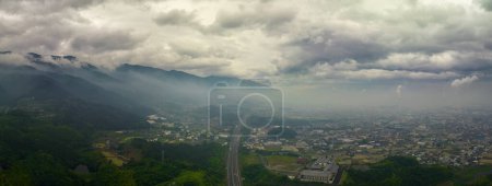 Téléchargez les photos : Autoroute par les montagnes brumeuses et la ville industrielle brumeuse avec des émissions de cheminée à Shikoku, Japon. Photo de haute qualité - en image libre de droit