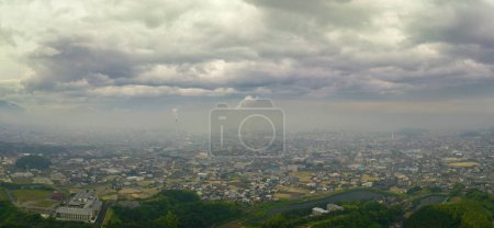 Téléchargez les photos : Vue aérienne panoramique de la ville brumeuse avec des cheminées sous un ciel nuageux. Photo de haute qualité - en image libre de droit