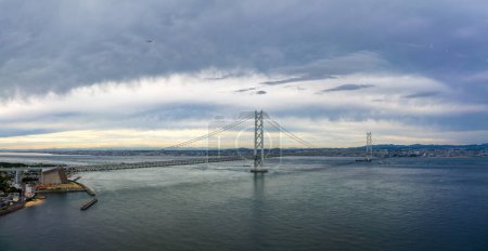 Photo for Panoramic view of long suspension bridge under clouds at dusk. High quality photo - Royalty Free Image
