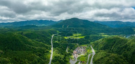 Photo for Aerial view of mountain roads by small village in green summer landscape in Tottori, Japan. High quality photo - Royalty Free Image
