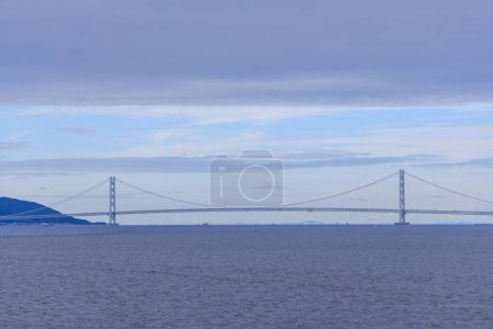 Photo for Low cloud layer over Akashi suspension bridge and calm blue water. High quality photo - Royalty Free Image