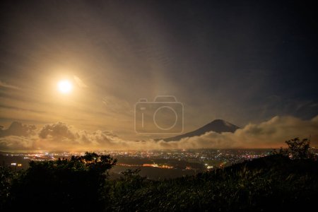 Téléchargez les photos : Superlune brille brillamment sur les nuages et la ville au pied du mont. Fuji. Photo de haute qualité - en image libre de droit