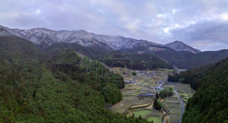 Reisterrassenfelder und schneebedeckte Berge in einem traditionellen japanischen Dorf. Hochwertiges Foto