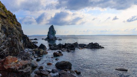 Formation rocheuse côtière de Sacred Kamitate Gamiiwa avec mer calme et horizon par une matinée nuageuse. Photo de haute qualité