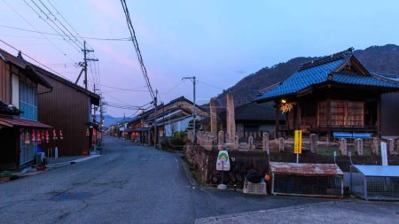 Téléchargez les photos : Rue calme avec maisons traditionnelles en bois dans le village japonais au coucher du soleil. Photo de haute qualité - en image libre de droit
