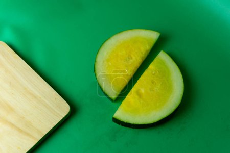 Téléchargez les photos : Gros plan de pastèque jaune tranchée avec fond vert. concept sain. - en image libre de droit