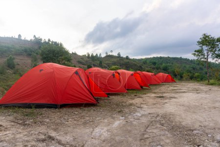 Téléchargez les photos : Camp tent area on the mountain. Red tents at the campsite. tourism concept. camping tent at sunset - en image libre de droit