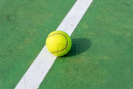 Photo for Top angle view of tennis ball on court. Yellow tennis ball on green court and white lines. - Royalty Free Image