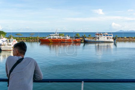 Téléchargez les photos : Sabang, Indonésie - 01 Juin 2023 : Un touriste à la recherche de passagers indonésiens navire KMP Papuyu à côté du navire de l'Agence nationale de recherche et de sauvetage à Ulee Lhee port à Aceh - en image libre de droit
