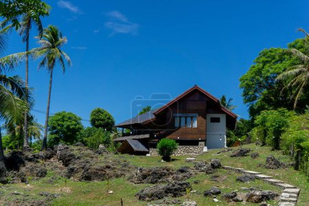 Téléchargez les photos : Maison de plage sur la terre rocheuse de l'île de Sabang à Aceh, Indonésie. Maison en bois sur le terrain de palmiers près de la plage. - en image libre de droit