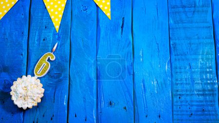 Téléchargez les photos : Top view copy space fond festif sur des planches bleues vintage avec tarte et décorations. Félicitations de fond pour votre anniversaire avec un numéro d'une bougie avec un numéro 6. - en image libre de droit