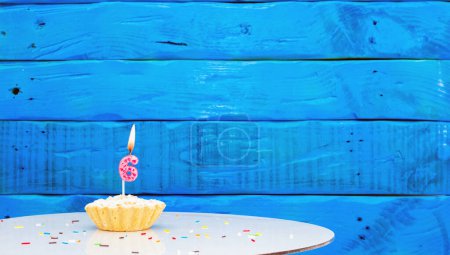 Téléchargez les photos : Fond festif avec un gâteau sur le fond de planches bleues, espace de copie, un beau fond pour un anniversaire avec un chiffre une bougie avec une figure 6 - en image libre de droit
