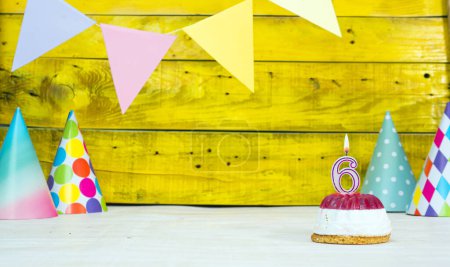 Téléchargez les photos : Carte colorée joyeux anniversaire avec des décorations festives avec gâteau et bougies allumées. Espace de copie. Beau fond joyeux anniversaire sur le fond de planches jaunes avec un certain nombre de bougies numéro 6. - en image libre de droit