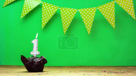 Photo for Colorful background happy birthday with decorations festive garlands with muffin on a green background with polka dots. Copy space. Beautiful happy birthday background with burning candles with number 1 - Royalty Free Image
