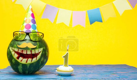 Photo for Funny watermelon in festive garlands for happy birthday greetings funny. Copy space watermelon with smile character. Happy birthday with number 1 - Royalty Free Image