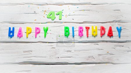Foto de Vista superior de los números felices de las velas de cumpleaños copia el espacio en tableros pastel blancos de madera. Hermosa tarjeta de cumpleaños con número 41 - Imagen libre de derechos