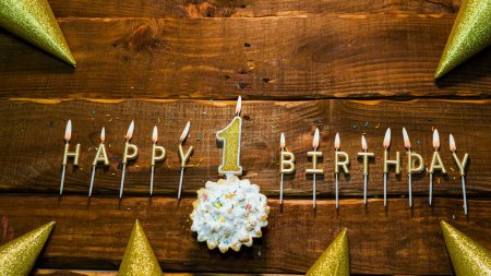Photo for Top view of the golden letters of the candle with the number happy birthday, the background of the pie with candles happy birthday on the background of brown stranded boards. Postcard Happy birthday  1 - Royalty Free Image