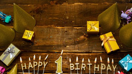 Photo for Top view of the golden letters of the candle with the number happy birthday, the background of the gift boxes with candles happy birthday on the background of brown boards. Copy space Postcard Happy birthday 1. - Royalty Free Image
