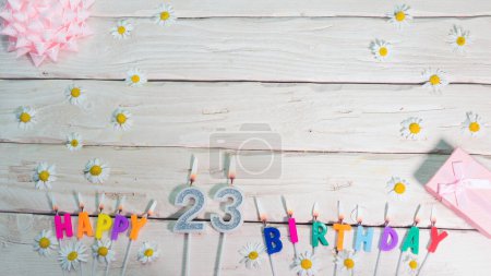 Téléchargez les photos : Une belle carte pour un anniversaire dans des couleurs pastel dans des tons roses avec un numéro 23. Les décorations de leurs bougies sont festives d'en haut, pour un couple ou une femme avec un espace de copie joyeux anniversaire - en image libre de droit