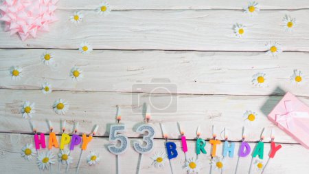 Téléchargez les photos : Une belle carte pour un anniversaire aux couleurs pastel dans des tons roses avec un numéro 53. Les décorations de leurs bougies sont festives d'en haut, pour un couple ou une femme avec un espace de copie joyeux anniversaire - en image libre de droit