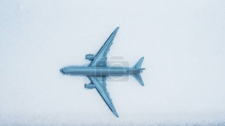 Téléchargez les photos : Avion dans une dérive de neige, modèle réduit d'avion dans la vue du haut de la neige - en image libre de droit