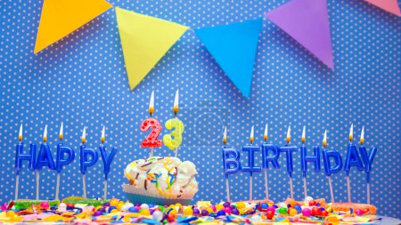 Téléchargez les photos : Happy birthday candle letter word for years old. Copy space Happy birthday greetings for 23 years, lit candles with holiday decorations. Beautiful holiday card. - en image libre de droit