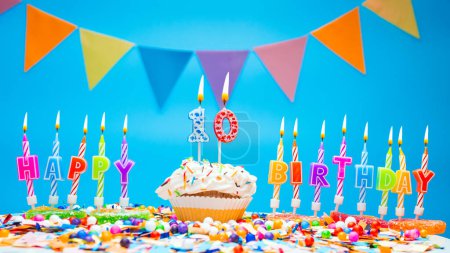Photo for A word made from candle letters happy birthday with the number on a beautiful blue background. Copy space Happy birthday greetings for 10 years, lit candles with holiday decorations. Beautiful holiday card - Royalty Free Image