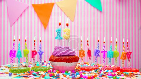 Photo for Happy birthday number 13. On a pink background, congratulations on the birthday of the thirteen year old. Muffins with pink cream with a burning candle. Copy space. - Royalty Free Image