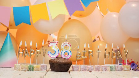 Téléchargez les photos : Happy birthday greetings for 38 years old from golden letters of candles burning against the background of mine space balloons. Beautiful birthday card with a muffin for thirty-eight years. - en image libre de droit