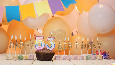 Téléchargez les photos : Happy birthday greetings for 53 years from gold letters of candles burning against the background of mine space balloons. Beautiful birthday card with a muffin for fifty-three years - en image libre de droit
