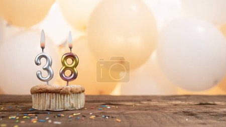Téléchargez les photos : Happy birthday card with candle number 38 in a cupcake against the background of balloons. Copy space happy birthday for thirty eight years old - en image libre de droit