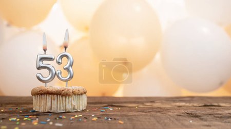 Téléchargez les photos : Happy birthday card with candle number 53 in a cupcake against the background of balloons. Copy space happy birthday for fifty three years old - en image libre de droit