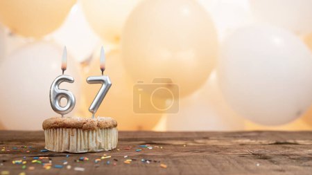 Photo for Happy birthday card with candle number 67 in a cupcake against the background of balloons. Copy space happy birthday for sixty seven years old - Royalty Free Image