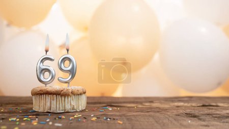 Foto de Happy birthday card with candle number 69 in a cupcake against the background of balloons. Copy space happy birthday for sixty nine years old - Imagen libre de derechos