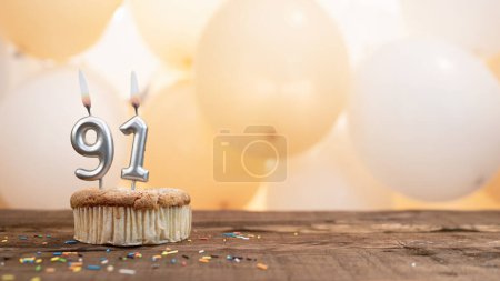 Happy birthday card with candle number 91 in a cupcake against the background of balloons. Copy space happy birthday for ninety one year