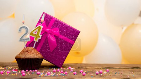 Téléchargez les photos : Happy birthday with a pink gift box for a 24 year old girl. Beautiful birthday card with a cupcake and a burning candle number twenty four - en image libre de droit