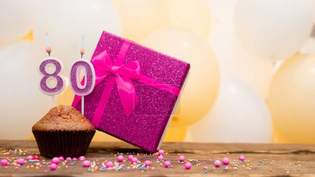 Téléchargez les photos : Happy birthday with pink gift box for 80 year old woman. Beautiful birthday card with a cupcake and a burning candle number eighty. - en image libre de droit
