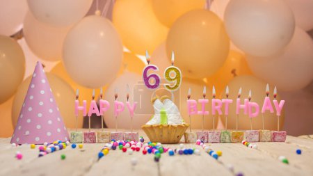 Foto de Beautiful background happy birthday number 69 with burning candles, birthday candles pink letters for sixty nine years. Festive background with balloons - Imagen libre de derechos
