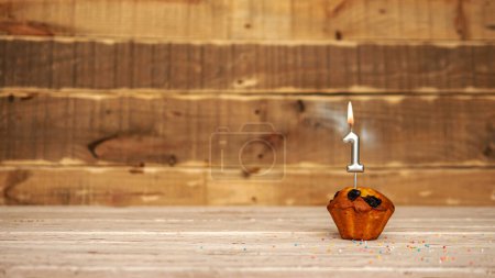 Photo for Scenery Festive wooden background happy birthday copy space. Anniversary background with number of burning candles and muffin. Beautiful brown from vintage boards background before a birthday with a number 1 - Royalty Free Image