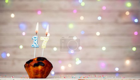 Photo for Happy birthday background with muffin and number of candles on light bulbs bokeh background. Greeting card happy birthday copy space with number 17 - Royalty Free Image