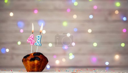 Foto de Happy birthday background with muffin and number of candles on light bulbs bokeh background. Greeting card happy birthday copy space with number 41 - Imagen libre de derechos