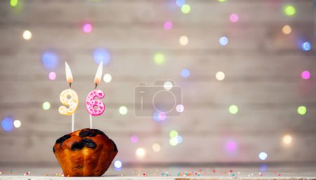 Foto de Happy birthday background with muffin and number of candles on light bulbs bokeh background. Greeting card happy birthday copy space with number 96 - Imagen libre de derechos