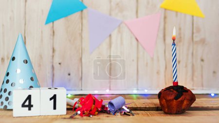 Foto de Festive Happy birthday background with number or digit  41. Postcard with a muffin and burning candles. Festive copy space background. - Imagen libre de derechos