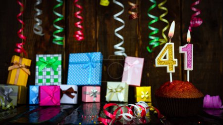 Téléchargez les photos : Party birthday background with number  41. Beautiful background anniversary copy space with burning candles. Gift boxes with decorations. - en image libre de droit