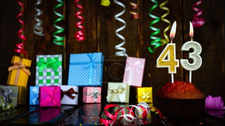 Téléchargez les photos : Party birthday background with number  43. Beautiful background anniversary copy space with burning candles. Gift boxes with decorations. - en image libre de droit