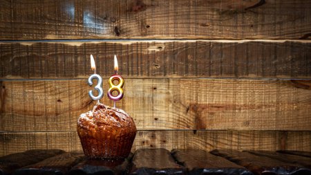 Foto de Background happy birthday pie or muffin with candles burning digit number  38. Festive card Happy Birthday on the background of vintage boards. Anniversary copy space - Imagen libre de derechos