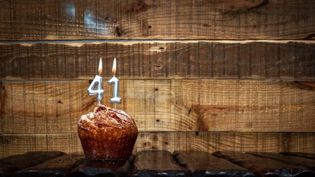 Foto de Background happy birthday pie or muffin with candles burning digit number  41. Festive card Happy Birthday on the background of vintage boards. Anniversary copy space - Imagen libre de derechos