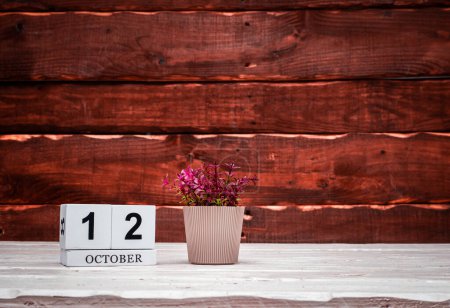 Foto de October calendar with number  12. Planner copy space on a wooden brown background. March number icon. Place for text background calendar - Imagen libre de derechos